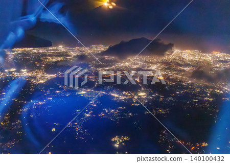 A view from the window of a passenger plane flying from Haneda Airport to Naha. A night view of Japan from 10,000 meters above ground. Naha Airport, Naha City, Okinawa Prefecture. A view from the window of a passenger plane flying from Haneda Airport to Naha. A night view of Japan from 10,000 meters above ground. Naha Airport, Naha City, Okinawa Prefecture. 140100432