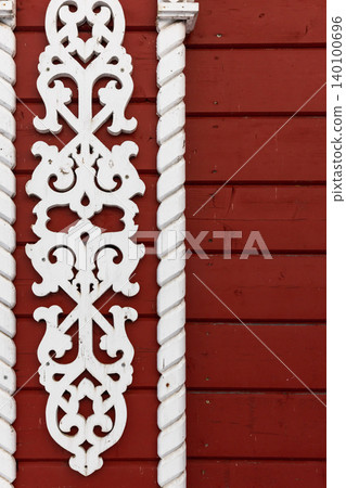 Carved white wooden trim with ornate scrollwork flanked by twisted columns 140100696