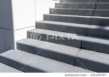 Modern concrete stairs ascend beside a white minimalist wall, background photography Modern concrete stairs ascend beside a white minimalist wall, background photography 140100707