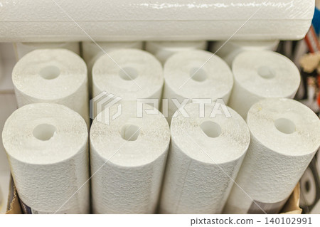 White textured wallpaper rolls stacked in home improvement store for renovation projects White textured wallpaper rolls stacked in home improvement store for renovation projects 140102991