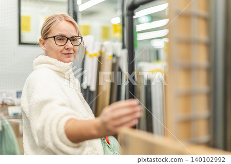 Woman choosing home improvement materials in modern hardware store Woman choosing home improvement materials in modern hardware store 140102992