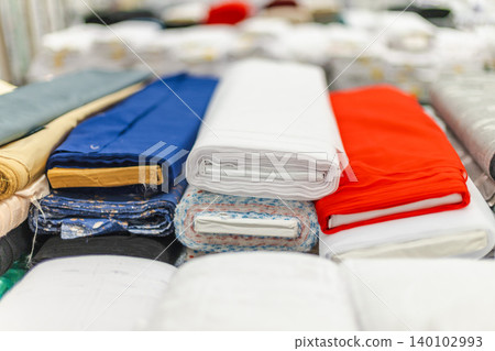 Colorful folded fabric and textile materials displayed in home improvement store Colorful folded fabric and textile materials displayed in home improvement store 140102993