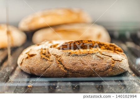 Fresh rustic artisan bread loaves displayed in bakery section with crispy crust and flour texture Fresh rustic artisan bread loaves displayed in bakery section with crispy crust and flour texture 140102994