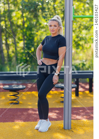 Young woman resting in outdoor fitness park during challenging workout session 140103427