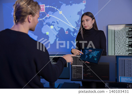 Cybersecurity analysts discussing threat detection strategies in the SOC control room 140103431