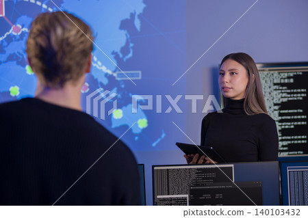 Team analyzing global cybersecurity data on advanced systems in monitoring center 140103432