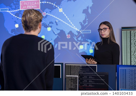 Team working in a cybersecurity operations center with digital monitoring tools 140103433
