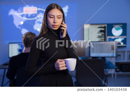 Cybersecurity analyst on a phone call in a SOC environment 140103436