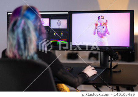 Young Female Video Editor Workstation with Modern Dual Monitors 140103459
