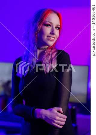 Young woman with vibrant hair in ambient purple studio lighting 140103461