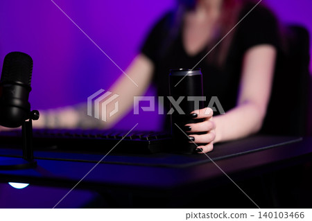 Young female gamer streaming online with modern equipment in vibrant lighting 140103466