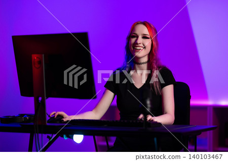 Young female gamer streaming online in a colorful gaming setup 140103467