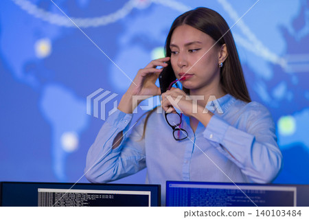 Female Analyst in Cybersecurity Control Room Monitoring Real-Time Global Threats 140103484