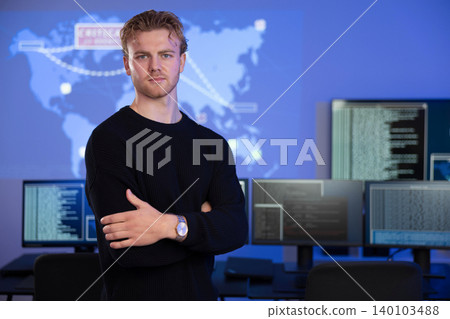 Confident cybersecurity analyst poses in front of data systems with extended monitors 140103488