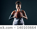 Close up portrait of a young woman professional basketball player holding a ball over a black background 140103664