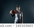Portrait of a young woman professional basketball player over a black background 140103665