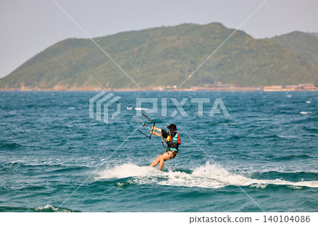Nha Trang, Khanh Hoa - Vietnam - April 4, 2026: Kitesurfer Cutting Through Waves in Open Sea 140104086