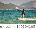 Nha Trang, Khanh Hoa - Vietnam - April 5, 2026: Kitesurfer Cutting Through Waves in Open Sea 140104105