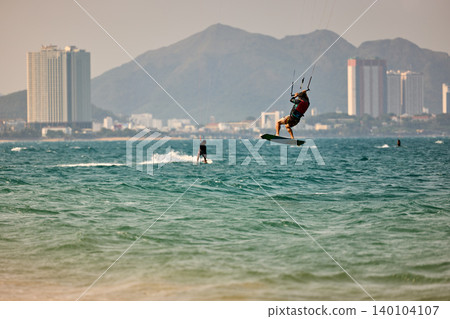 Nha Trang, Khanh Hoa, Vietnam - April 5, 2026: Kitesurfer Performing High Jump Above Waves in Nha Trang Nha Trang, Khanh Hoa, Vietnam - April 5, 2026: Kitesurfer Performing High Jump Above Waves in Nha Trang 140104107