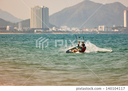Nha Trang, Khanh Hoa - Vietnam - April 6, 2026: Kitesurfer Cutting Through Waves in Open Sea 140104117