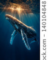 Whale swims underwater in the ocean. Golden sunlight beams through the water. 140104848