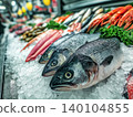 Large fish on ice at a seafood market display. Bright market lights highlight fresh seafood. 140104855