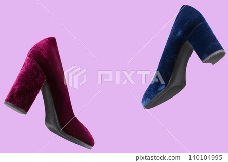 Two levitating velvet block high heel pumps in burgundy and blue on lilac background. Floating luxury women's shoes composition with central copy space, creative product photography. Two levitating velvet block high heel pumps in burgundy and blue on lilac background. Floating luxury women's shoes composition with central copy space, creative product photography. 140104995