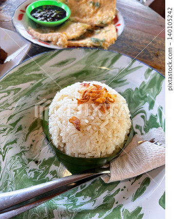 Scoop of white steamed rice topped with crispy fried shallots, home cooking Scoop of white steamed rice topped with crispy fried shallots, home cooking 140105242