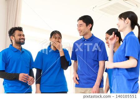 Multinational caregivers smiling and chatting at a nursing home. Multinational caregivers smiling and chatting at a nursing home. 140105551