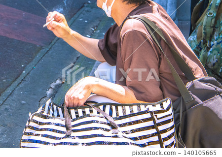 在日本橫濱，一個老人在車站前肆無忌憚地抽煙，彷彿這裡是他的地盤……然後他把煙頭扔到我們面前…… 140105665
