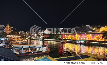 夜晚,中國波光粼粼的水鄉小鎮成為畫面的背景。 夜晚,中國波光粼粼的水鄉小鎮成為畫面的背景。 140105760