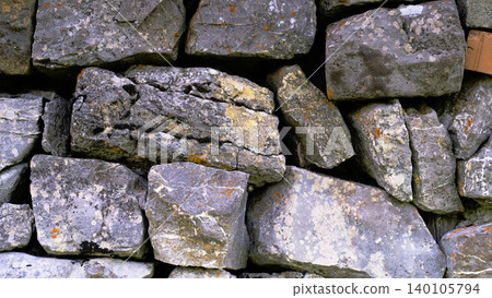 Rocks stacked together form a sturdy wall in an outdoor setting during daylight hours Rocks stacked together form a sturdy wall in an outdoor setting during daylight hours 140105794