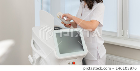 Female cosmetologist operating a modern laser hair removal machine Female cosmetologist operating a modern laser hair removal machine 140105976