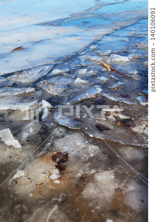 Frozen lake surface with melting ice fragments 140106091