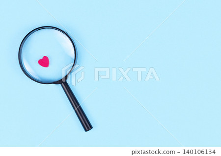 Looking for love concept with magnifier glass and pink heart icon on blue background with copy space Looking for love concept with magnifier glass and pink heart icon on blue background with copy space 140106134