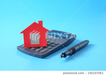 Red house model on calculator and pen . 140107061