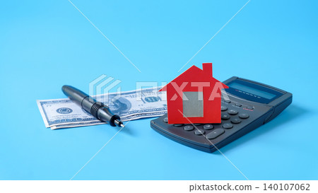 Red house model on calculator and pen . Red house model on calculator and pen . 140107062