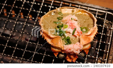 close up of grilled crab shell with kani miso, crab meat, and green onion garnish, which is a traditional Japanese seafood delicacy called Crab Miso on Shell on the stove with copy space close up of grilled crab shell with kani miso, crab meat, and green onion garnish, which is a traditional Japanese seafood delicacy called Crab Miso on Shell on the stove with copy space 140107410