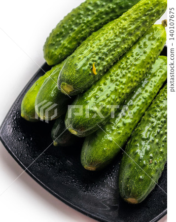 Fresh Cucumbers Arranged On Black Plate Fresh Cucumbers Arranged On Black Plate 140107675