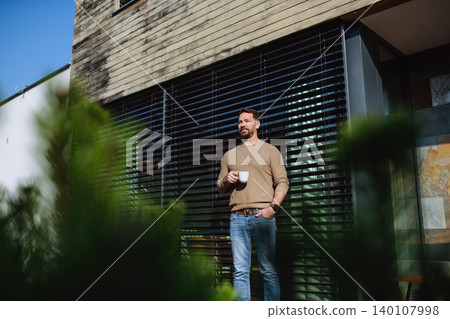 Relaxed man drinking coffee on terrace at home on sunny day. Relaxed man drinking coffee on terrace at home on sunny day. 140107998