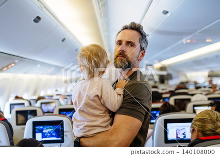 Father taking care of toddler during family flight. Father taking care of toddler during family flight. 140108000