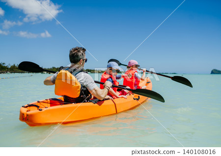 Father kayaking with daughter on calm sea during family summer vacation. Father kayaking with daughter on calm sea during family summer vacation. 140108016