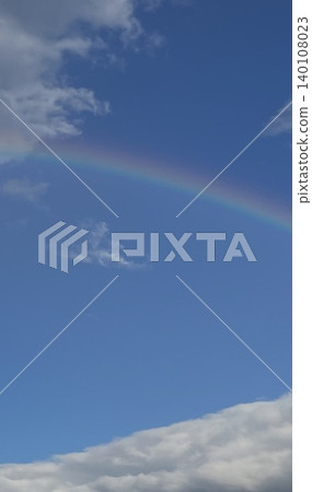 A rainbow and white clouds in the blue sky after the rain. 140108023