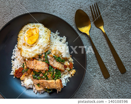 Rice topped with crispy pork belly with Thai basil and fried egg Rice topped with crispy pork belly with Thai basil and fried egg 140108596