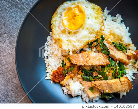 Rice topped with crispy pork belly with Thai basil and fried egg Rice topped with crispy pork belly with Thai basil and fried egg 140108597