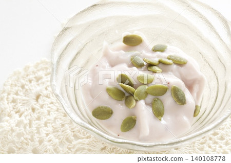 Pink yogurt topped with pumpkin seeds Pink yogurt topped with pumpkin seeds 140108778
