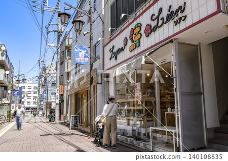 A street lined with bakeries and shops in front of Nagahara Station. 140108835