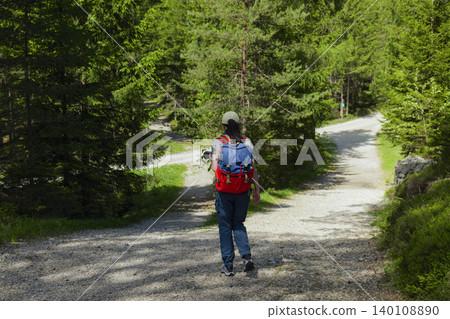 Female hiker with backpack on a winding path in the Austrian Alps, highlighting an adventure lifestyle and outdoor freedom Female hiker with backpack on a winding path in the Austrian Alps, highlighting an adventure lifestyle and outdoor freedom 140108890