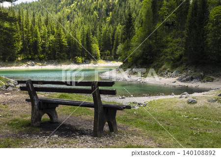 Serene wooden bench overlooking the Gruner See, Austria, illustrating the impact of climate variability on mountain ecosystems Serene wooden bench overlooking the Gruner See, Austria, illustrating the impact of climate variability on mountain ecosystems 140108892