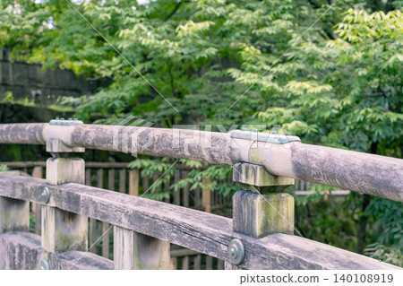 木質橋樑欄桿在綠色背景下的水平構圖。 木質橋樑欄桿在綠色背景下的水平構圖。 140108919